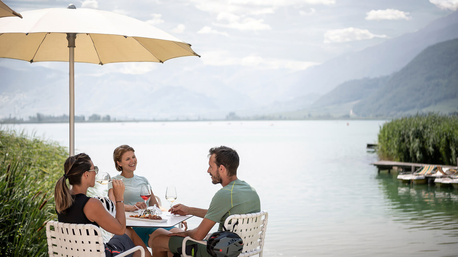 Freunde sitzen am Ufer des Kalterer Sees